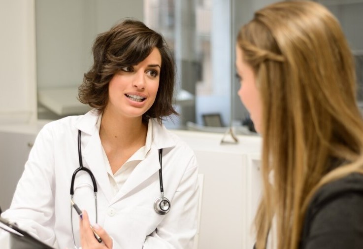 Doctora explicando a una paciente qué es la salpingoclasia, y cómo se realiza, en una consulta médica